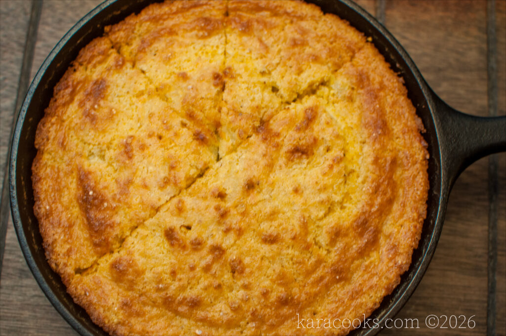 a closeup of a cast iron skillet filled with lightly browned southern style cornbread