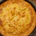 a closeup of a cast iron skillet filled with lightly browned southern style cornbread