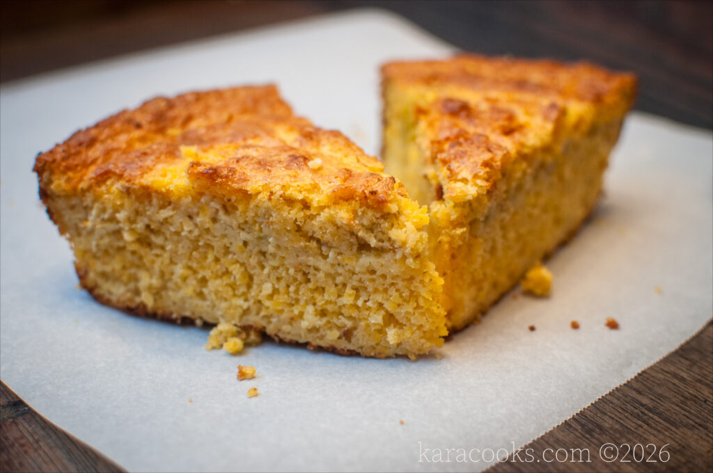 two wedges of southern style cornbread on a sheet of white parchment paper